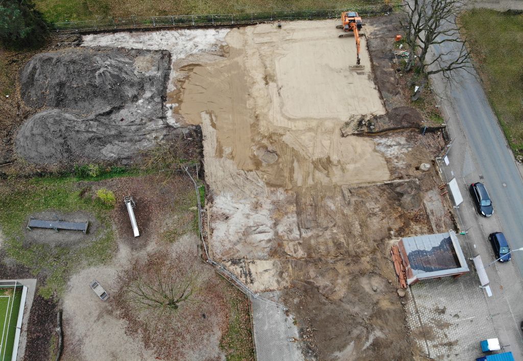 Das Luftbild zeigt die Baustelle des Feuerwehrgerätehauses am 23.11.2019. Ein Bagger verteilt Sand auf dem zukünftigen Bauplatz.