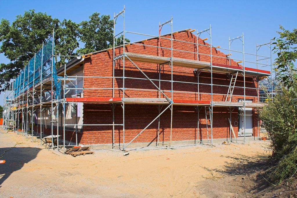 Das Bild zeigt das Dienstgebäude des Feuerwehrgerätehauses in Otternhagen, dass eine rote Klinkerfassade erhält. Auf der Rückseite sind die Klinkerarbeiten bereits fertiggestellt.