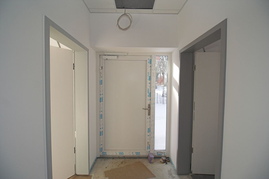 Zugangsbereich mit Haupteingang (in der Bildmitte), Durchgang zum Büroraum (linke Tür) und Zugang zum Küchenbereich (rechte Tür).