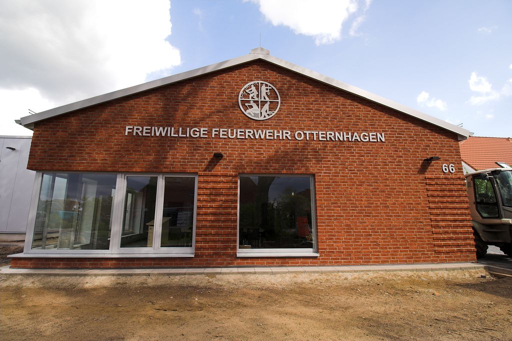 Das Foto zeigt, wie das Feuerwehrsymbol sowie die Beschriftung an der Giebelseite des Dienstgebäudes deutlich sichtbar auf das neue Feuerwehrgerätehaus Otternhagen hinweisen.